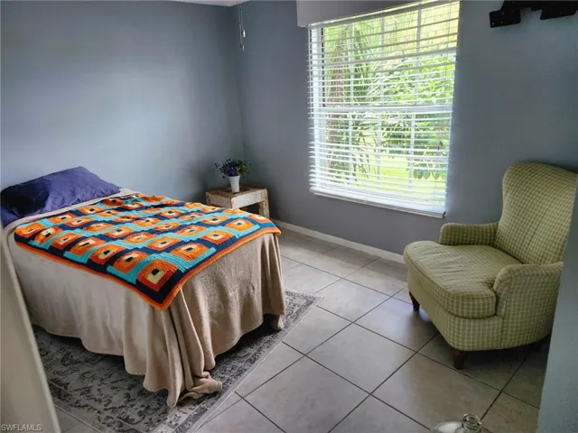 Bedroom featuring light tile patterned floors and large windows
