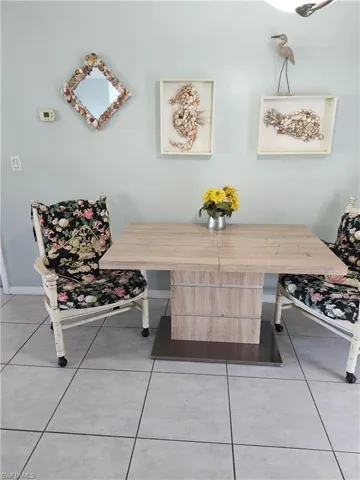 Dining space with light tile patterned flooring