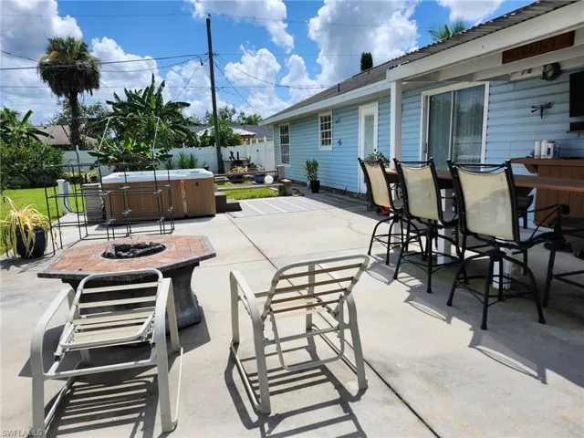 View of patio / terrace featuring a hot tub and an outdoor fire pit