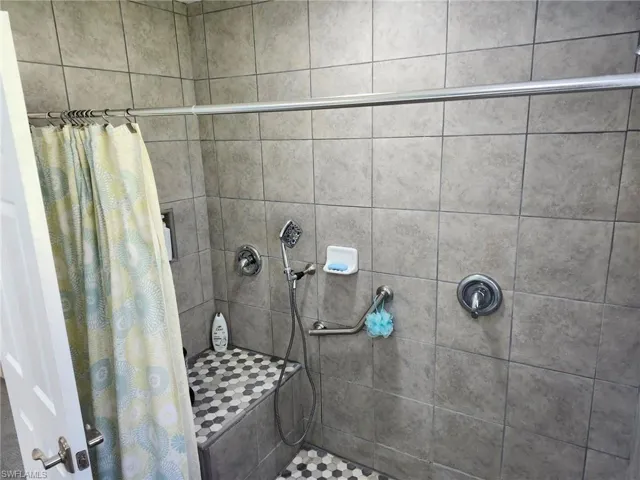 Bathroom to primary bedroom with a shower with curtain