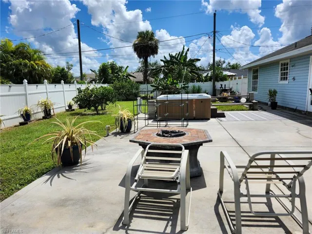 View of patio featuring a hot tub and an outdoor fire pit
