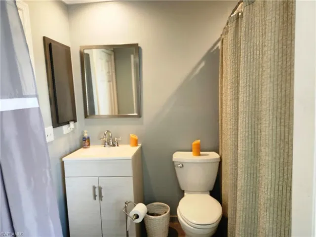Bathroom to hall and secondary master featuring toilet and vanity