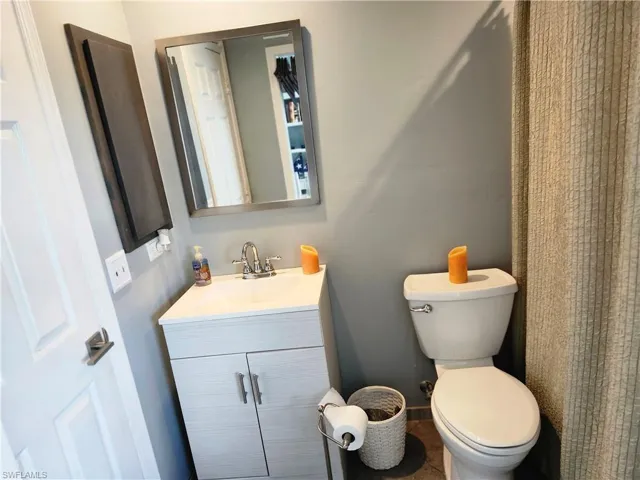 Bathroom with toilet, vanity, and tile patterned flooring