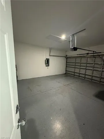 Garage featuring electric panel and a garage door opener