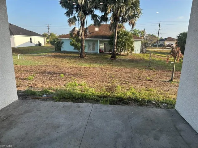 View of green lawn with covered porch