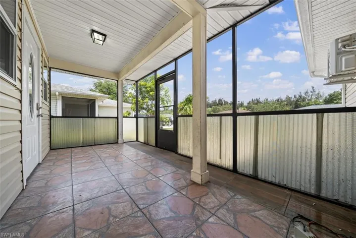 Screened porch featuring large format stone-finish tile flooring, a white paneled ceiling, and a light fixture