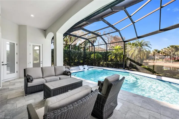 Outdoor pool with a patio, a sunroom, glass enclosure, outdoor seating, and french doors