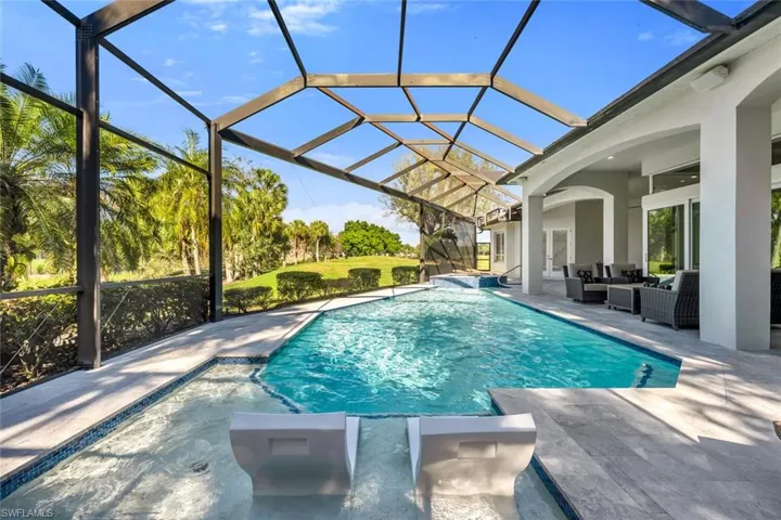 Swimming pool with a sunroom, an outdoor living space, glass enclosure, and a patio area