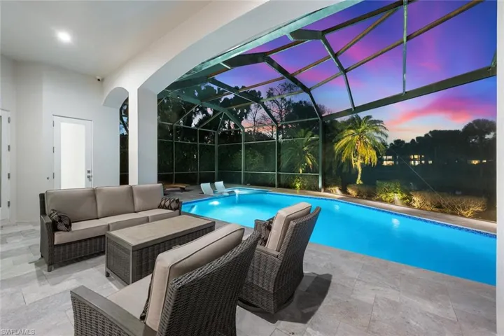 Outdoor pool featuring a patio area, an outdoor hangout area, a sunroom, and glass enclosure