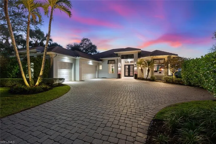 Prairie-style house with an attached garage, stucco siding, decorative driveway, and french doors