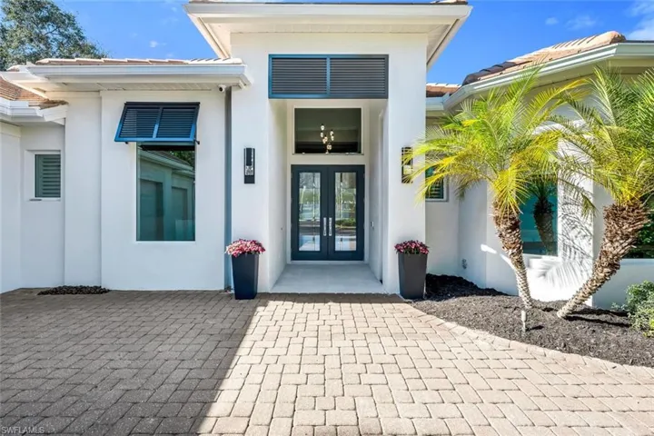 View of exterior entry with french doors, stucco siding, and a tiled roof