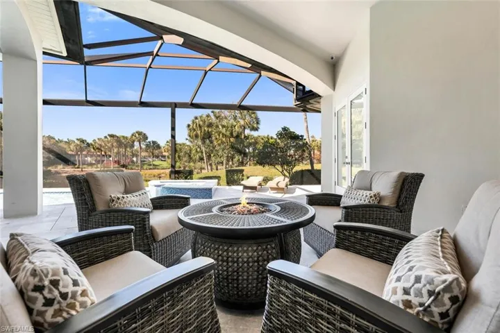 View of patio featuring a sunroom, a lanai, and an outdoor living space with a fire pit