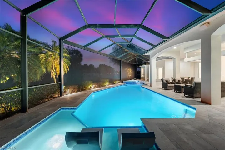 Relaxing pool / spa featuring a lanai, outdoor furniture, a sunroom, and a patio
