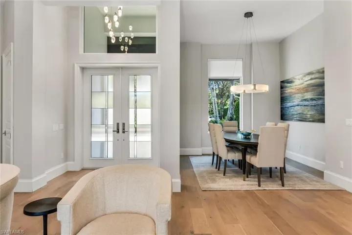 Dining space featuring french doors, hanging lights, and light wood-style floors
