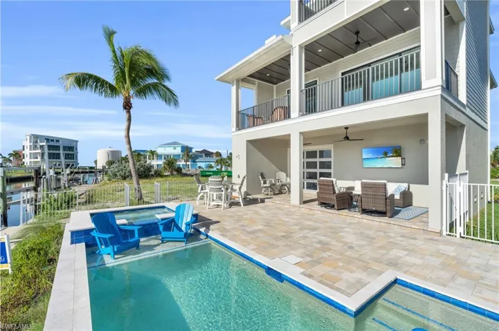 View of swimming pool with a patio area, outdoor lounge area, a water view, ceiling fan, and an in ground hot tub