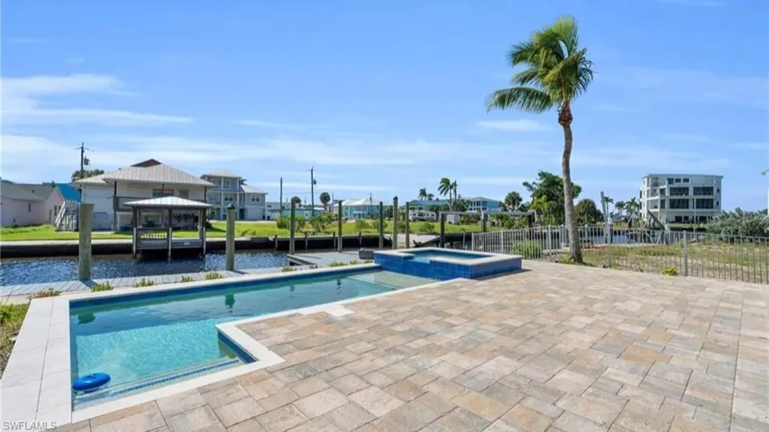 View of swimming pool with a water view, a patio, and a gazebo