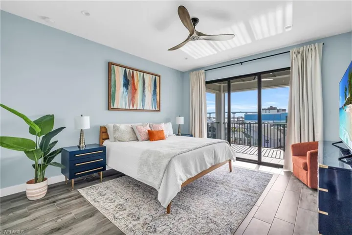 Bedroom featuring access to outside, hardwood / wood-style floors, and ceiling fan