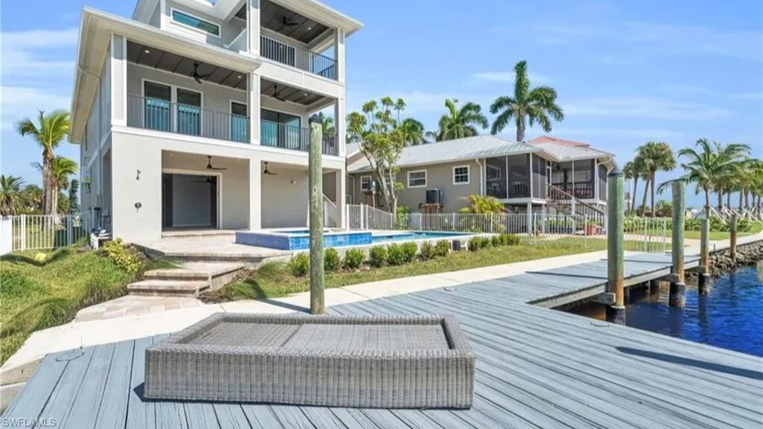 Rear view of property with a fenced in pool, a water view, a patio area, and a balcony