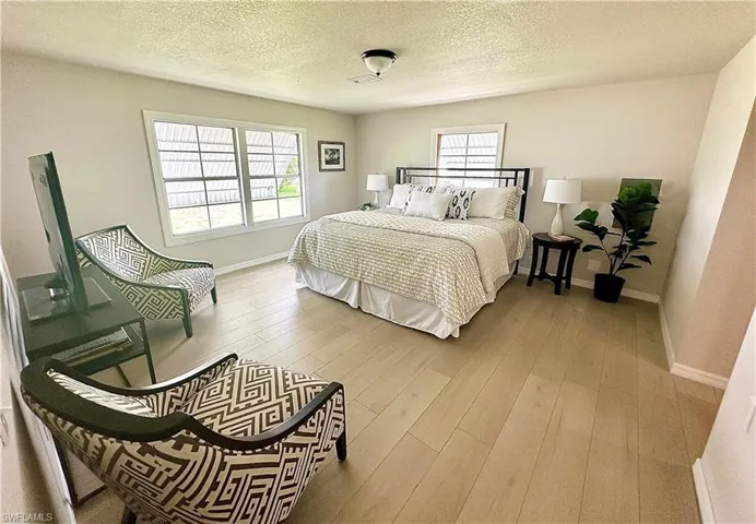 Bedroom featuring hardwood / wood-style flooring and a textured ceiling