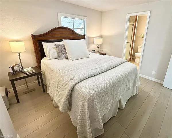 Bedroom featuring connected bathroom and light wood-type flooring