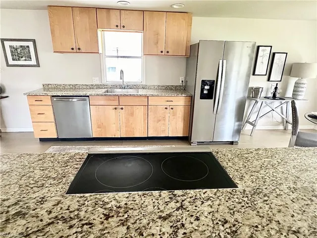 Kitchen featuring appliances with stainless steel finishes and sink