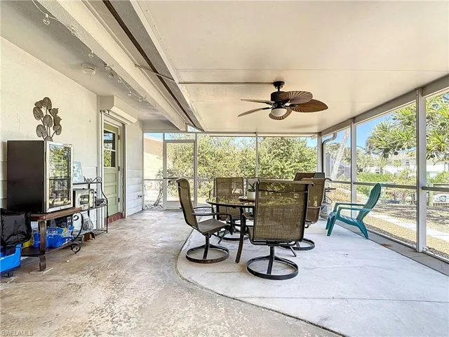 Sunroom / solarium featuring ceiling fan, healthy amount of natural light, and outdoor dining area