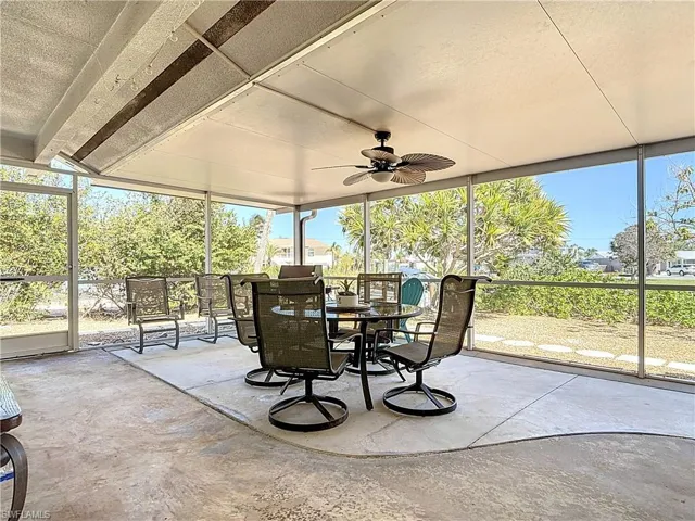 Sunroom featuring ceiling fan, outdoor dining area, and a patio