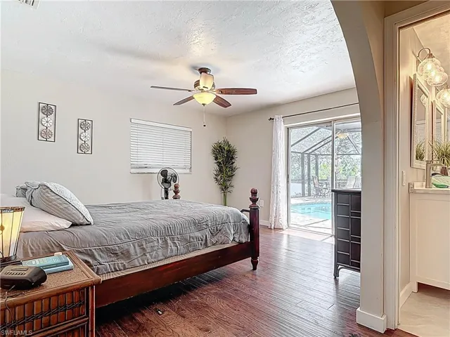 Bedroom with access to outside, a textured ceiling, hardwood / wood-style floors, and a ceiling fan