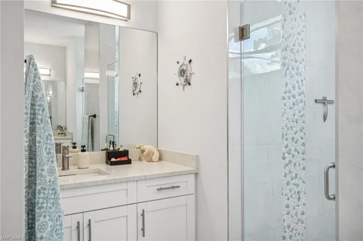Bathroom featuring an enclosed shower and vanity