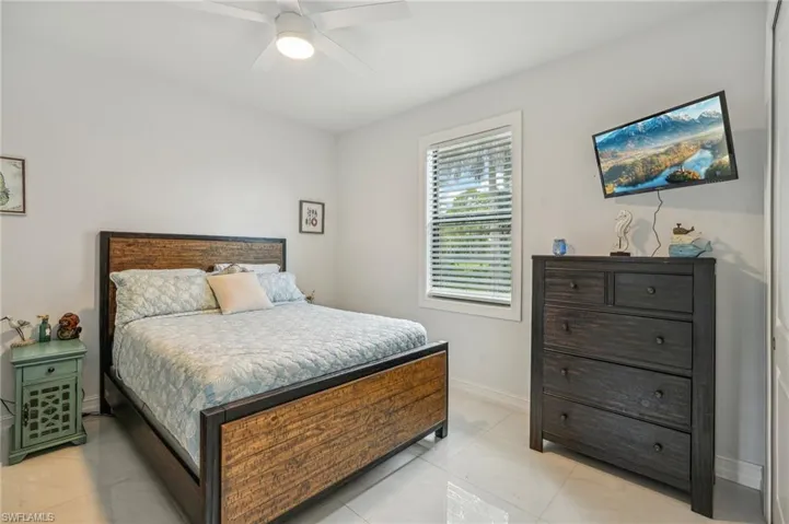 Bedroom with light tile patterned flooring and ceiling fan