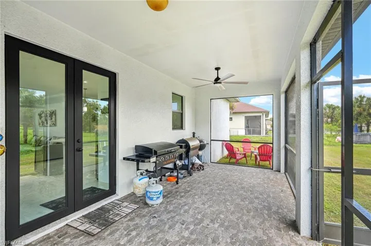 Sunroom / solarium featuring ceiling fan and french doors