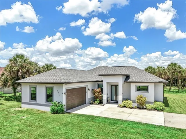 View of front of house with a garage and a front lawn