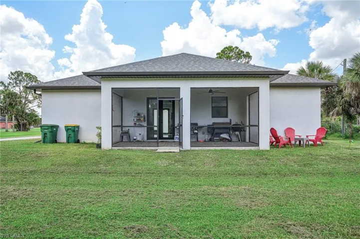 Rear view of property with ceiling fan, a patio, and a yard