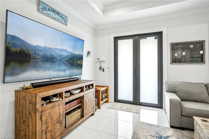 Entrance foyer featuring french doors, light tile patterned flooring, and ornamental molding