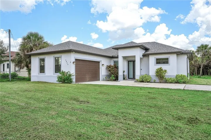 Prairie-style home with a garage and a front lawn