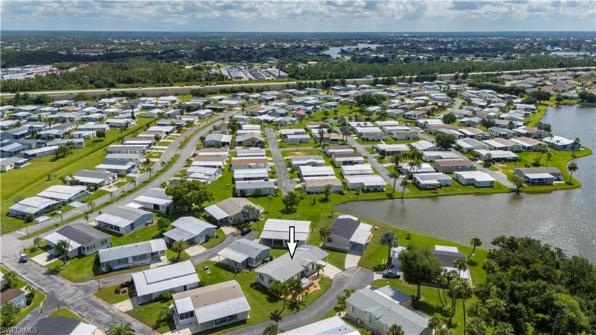 Aerial view of property and surrounding area featuring a large body of water and nearby suburban area