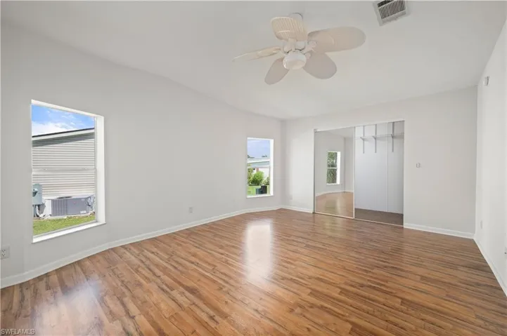 Unfurnished bedroom with wood finished floors, a closet, and a ceiling fan