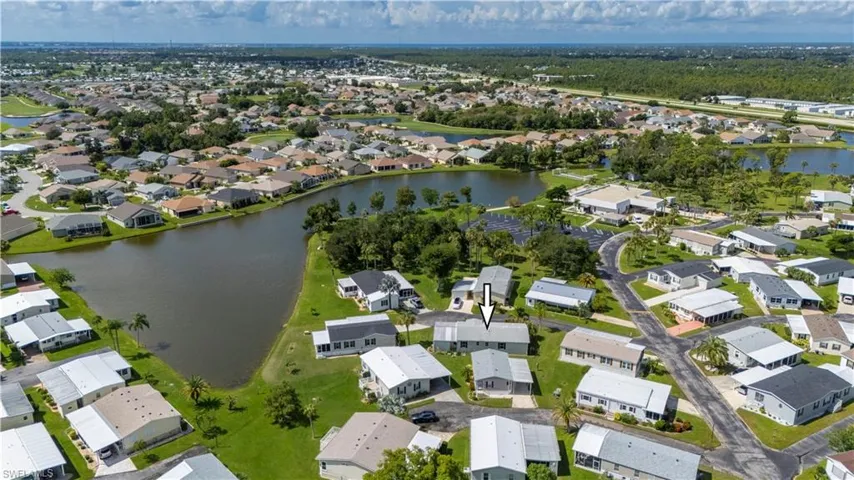 Aerial view of property and surrounding area with a large body of water and nearby suburban area