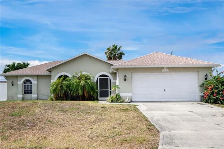 Attractive single-story home with a two-car garage, screened front entry, arched windows, and a durable shingle roof