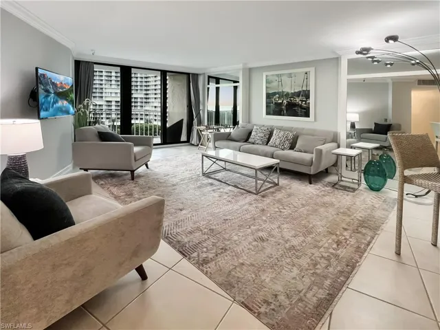 Living room featuring crown molding, light tile patterned flooring, and a wall of windows