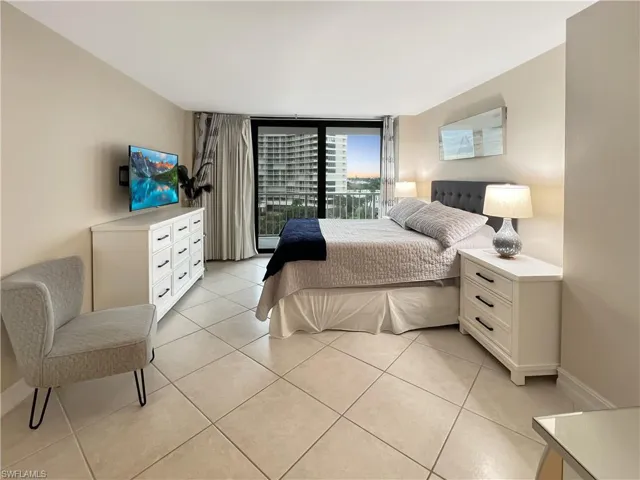 Bedroom featuring light tile patterned floors and expansive windows