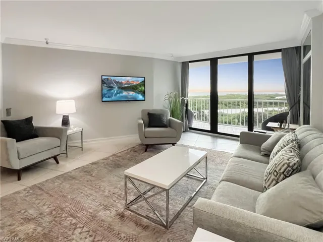 Living area featuring floor to ceiling windows, ornamental molding, and light tile patterned floors
