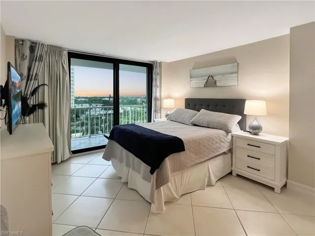 Bedroom featuring access to exterior, light tile patterned floors, and floor to ceiling windows