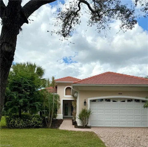 View of front facade featuring a front lawn and a garage