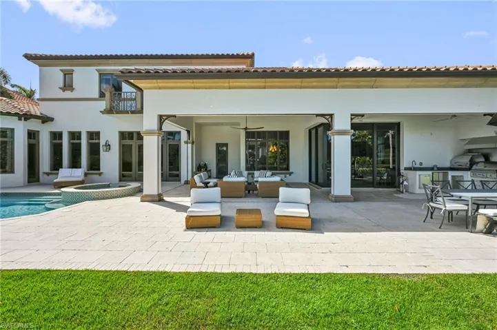 Rear view of house with an outdoor kitchen, a ceiling fan, a patio area, and a pool with connected hot tub
