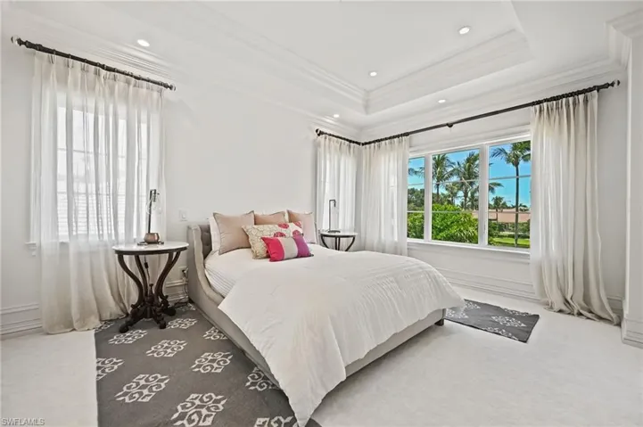 Carpeted bedroom with crown molding, a tray ceiling, and recessed lighting