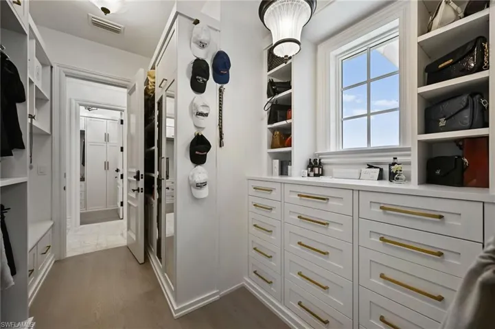 Walk in closet featuring dark wood finished floors