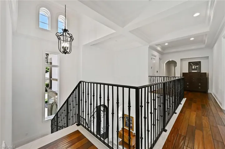 Hallway with coffered ceiling, beam ceiling, dark wood finished floors, and recessed lighting