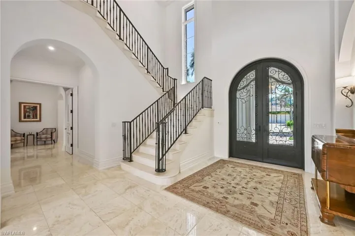 Entrance foyer with arched walkways, plenty of natural light, french doors, and a towering ceiling