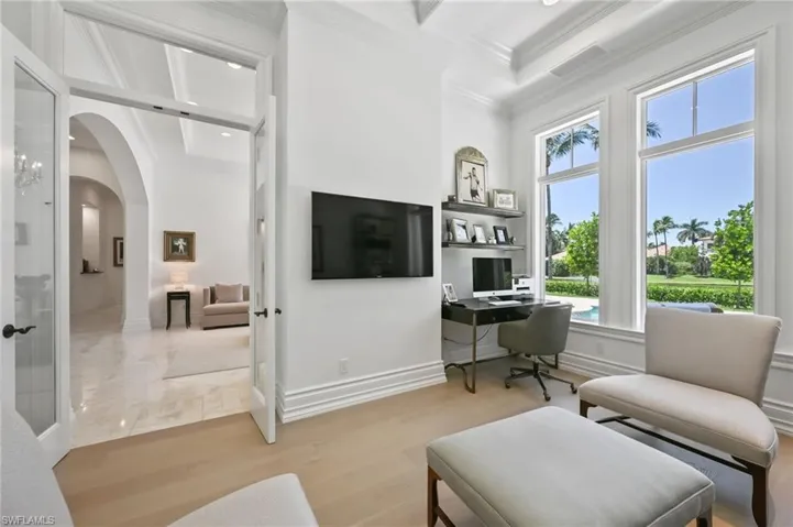 Home office with ornamental molding, light wood-type flooring, arched walkways, and recessed lighting